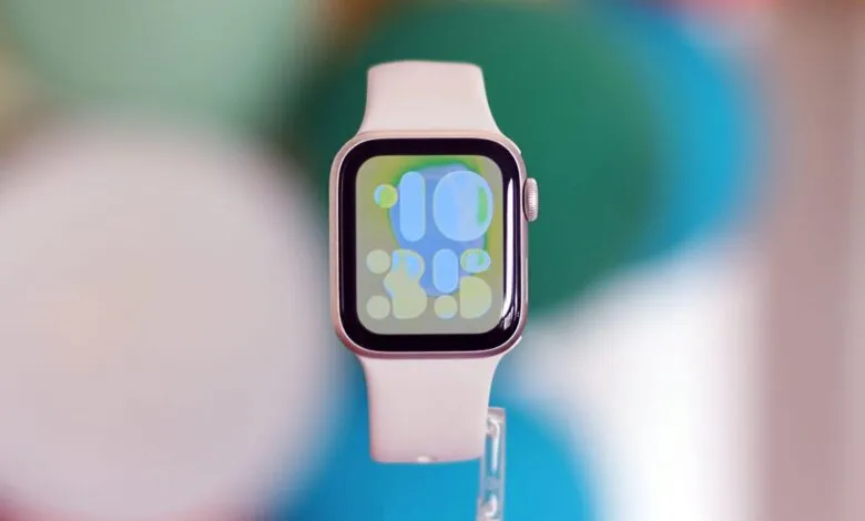 Close-up of a white Apple Watch Series 7 with a colorful watch face.