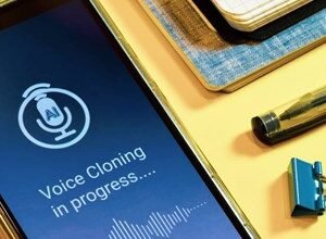 Smartphone screen displaying 'Voice Cloning in progress' with AI icon and waveform.