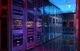 Modern server room with rows of illuminated racks and blue ceiling lights.