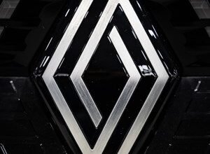 Close-up of the silver Renault diamond logo on a black background.