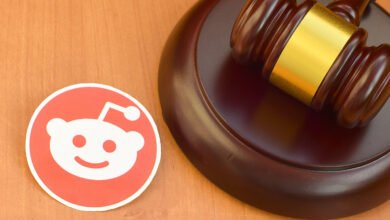 Reddit logo next to a wooden judge's gavel on a wooden surface.