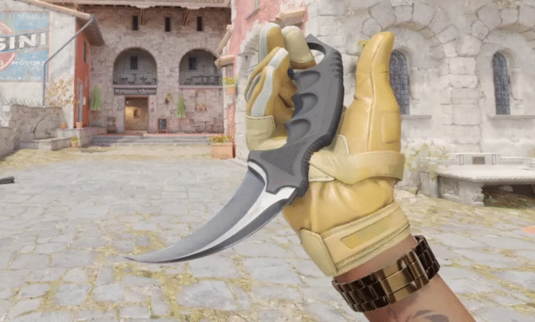 A gloved hand holds a curved combat knife with a gray handle.