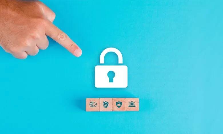 A finger points towards a large white padlock icon above four wooden blocks with security icons.
