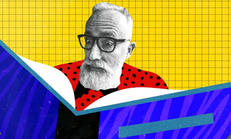 Man with glasses and beard reading a book with a vibrant yellow grid background.