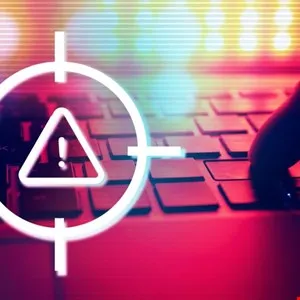 Cybersecurity alert symbol within a crosshair overlayed on a keyboard.
