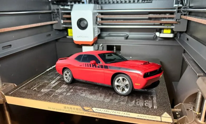 Red Dodge Challenger model car on a 3D printer bed