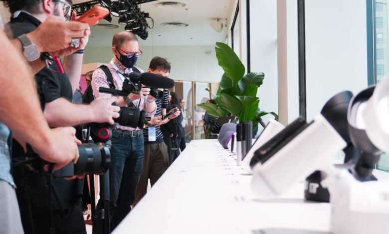 Media professionals filming and photographing products at a launch event.