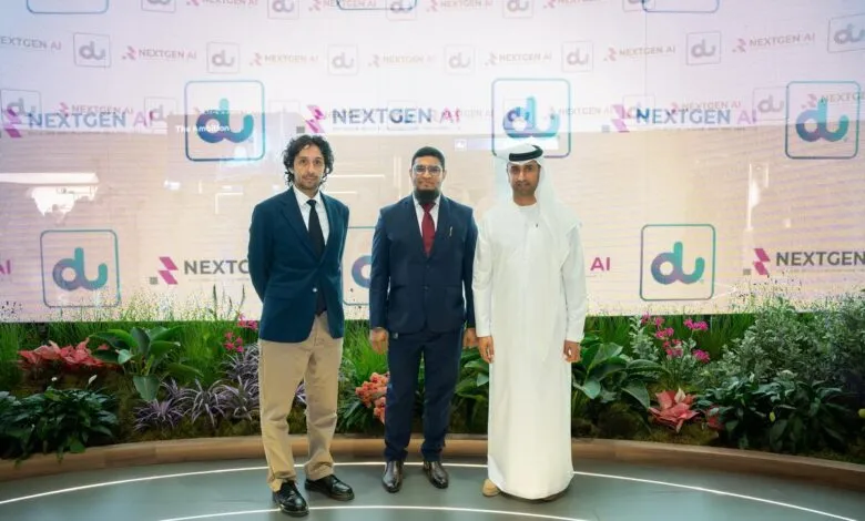 Three men stand in front of a digital display featuring 'du NEXTGEN AI' logos.
