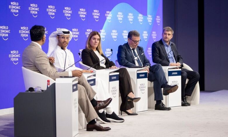 Panelists seated on a stage at the World Economic Forum, with the forum's logo visible.