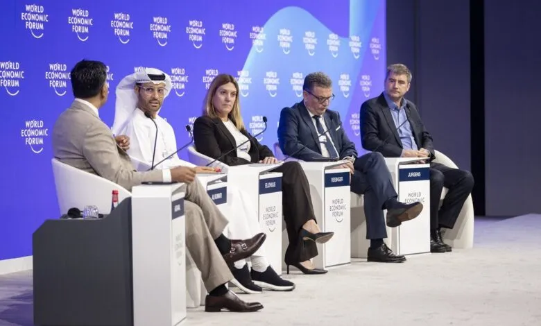 Panelists seated on a stage at the World Economic Forum, with the forum's logo visible.