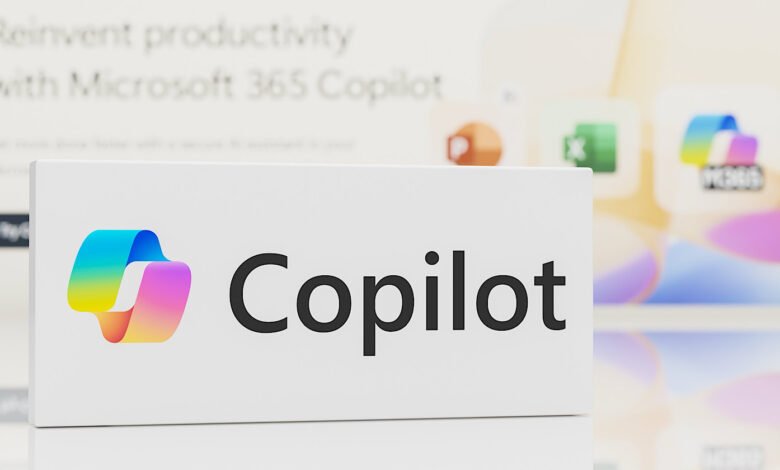 Microsoft Copilot logo and name on a white display, with blurred app icons in the background.