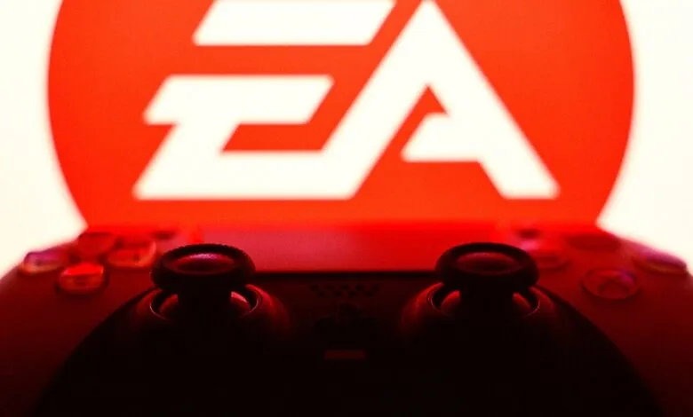 Close-up of a black game controller in silhouette against the glowing red EA logo.