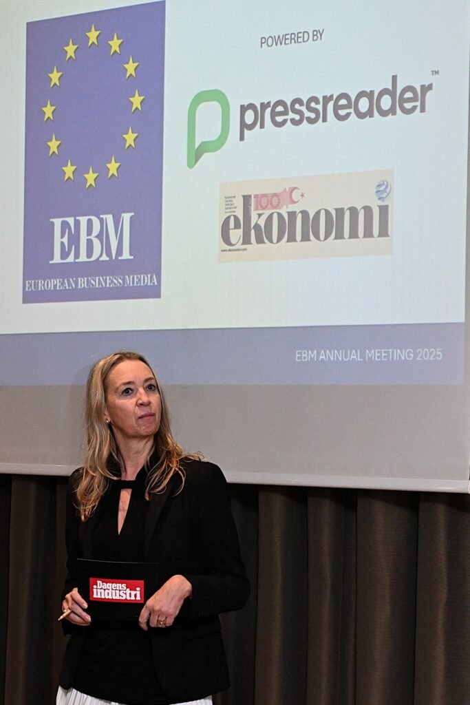 Woman in black blazer holding a Dagens Industri folder at EBM Annual Meeting 2025