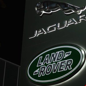 Jaguar and Land Rover logos illuminated on a dark background.