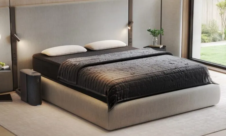A modern bedroom featuring a king-size bed with a dark gray quilted comforter and two white pillows.
