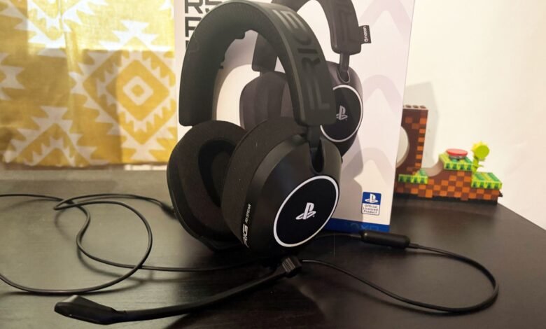 Black PlayStation gaming headset with microphone on a dark surface.