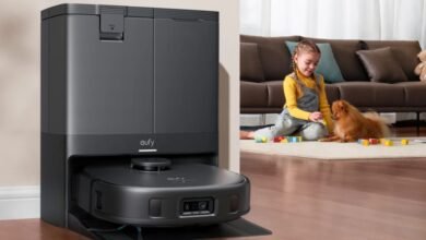 Eufy X10 Omni robot vacuum docked in its charging station next to a child and dog playing.