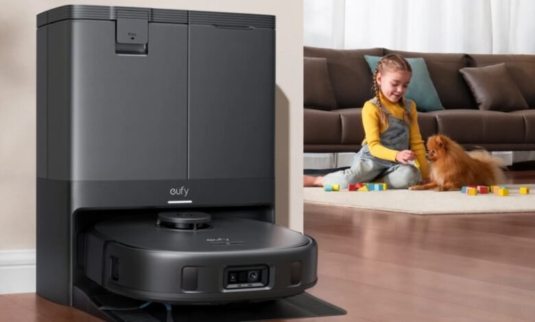 Eufy X10 Omni robot vacuum docked in its charging station next to a child and dog playing.