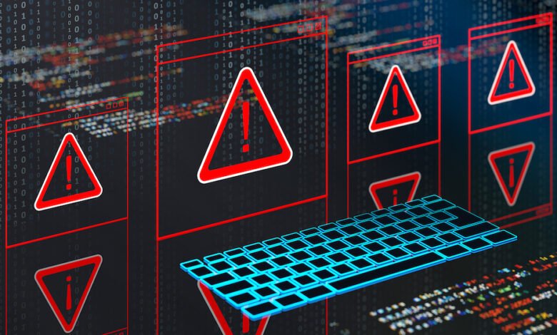 Multiple warning signs with exclamation marks on computer screens, with a glowing keyboard.
