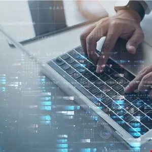 Close-up of hands typing on a laptop keyboard with digital overlay.