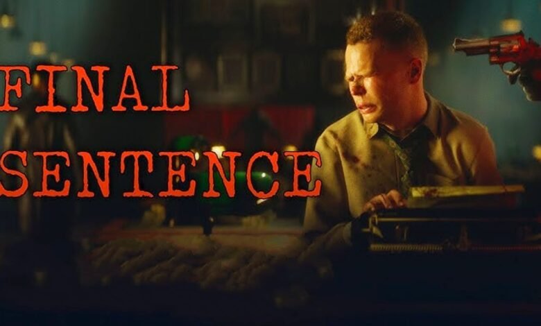 Man typing on a typewriter with a gun pointed at him.