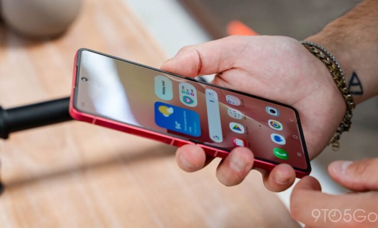 Close-up of a person holding a red Samsung Galaxy Z Flip smartphone, showing the home screen.