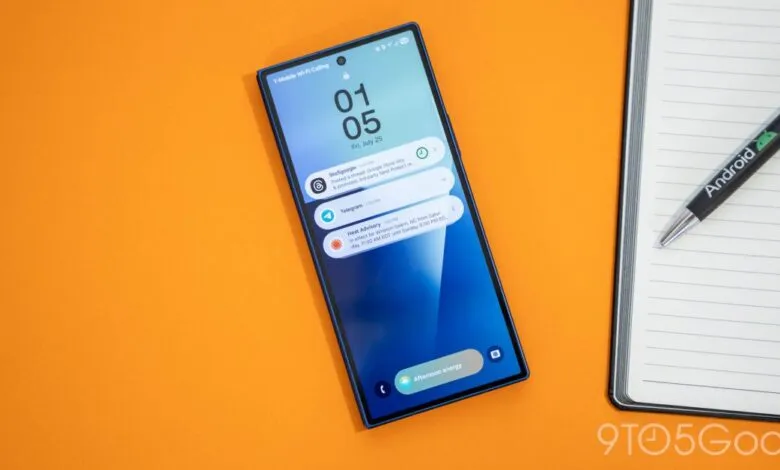 Close-up of a smartphone displaying notifications and a pen with the Android logo on a notepad.