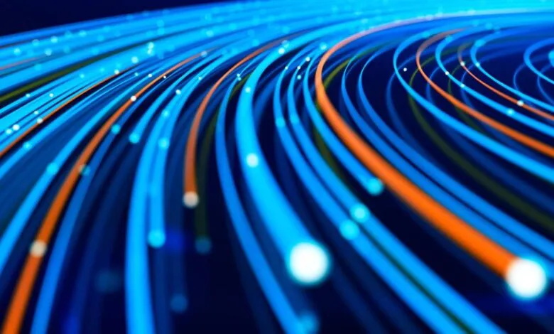 Abstract visualization of glowing blue and orange data streams flowing in a network.