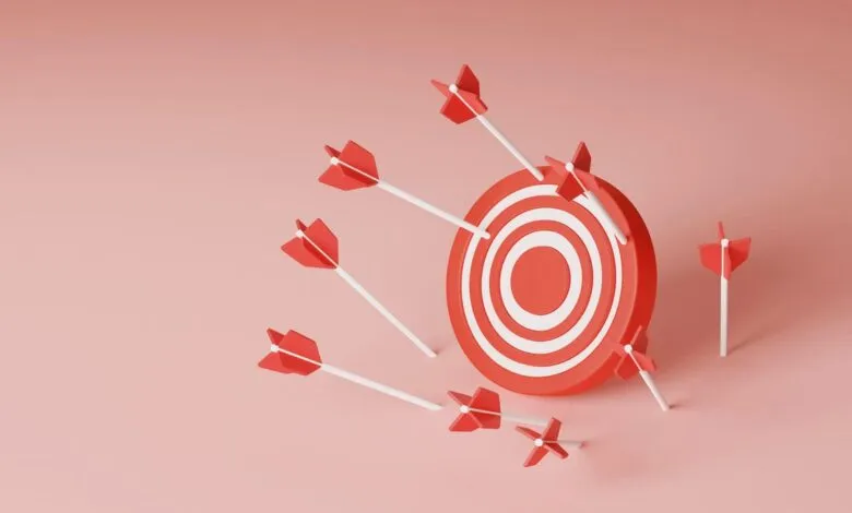 Red and white target with several arrows missing the bullseye on a pink background.