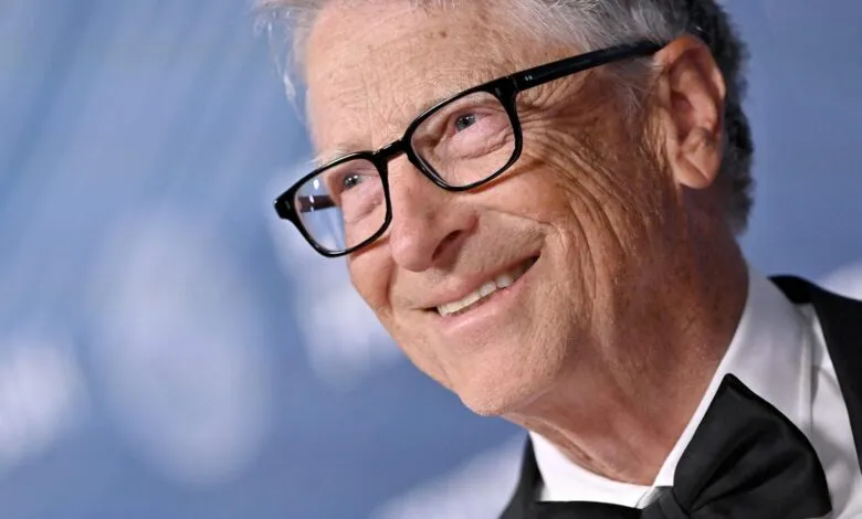 Close-up of Bill Gates wearing glasses and a tuxedo, smiling.