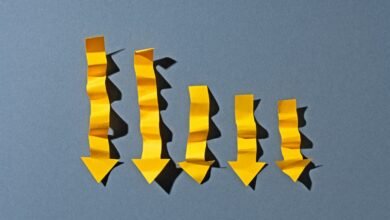 Five yellow paper arrows pointing downwards, arranged in a descending graph pattern.
