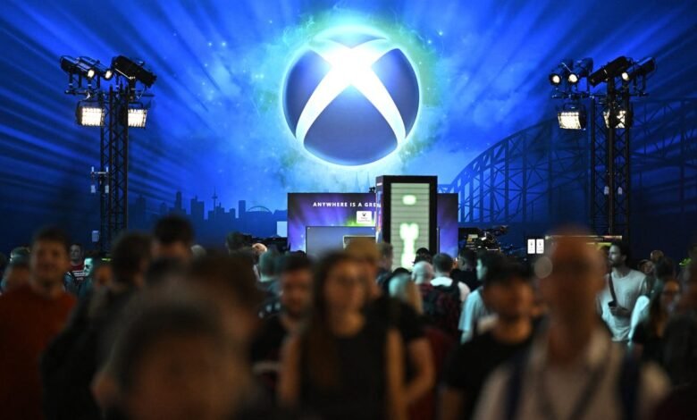 The iconic Xbox logo glows brightly against a blue, starry background at a gaming event.