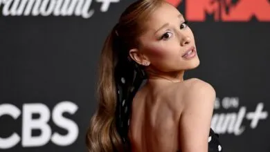 Ariana Grande poses for a photo, looking over her shoulder with a smile.