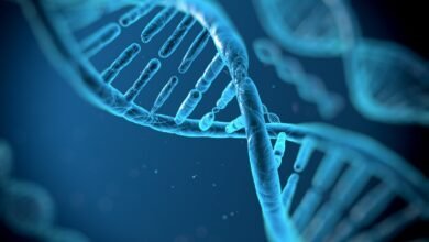 Close-up of a glowing blue DNA double helix structure against a dark background.