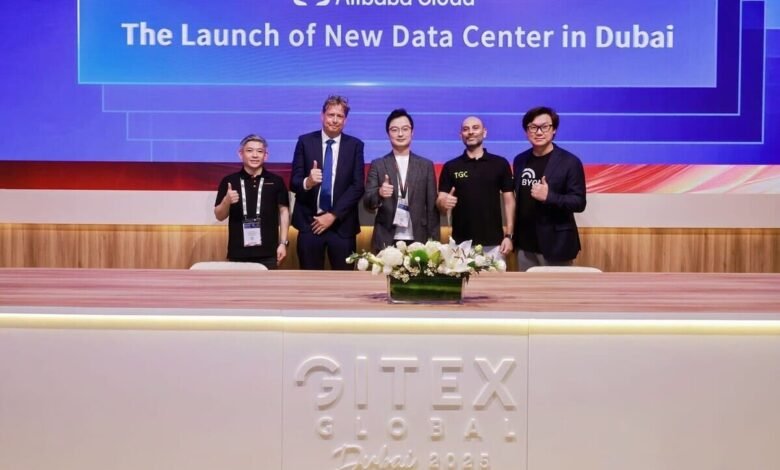 Five men stand behind a table with a floral arrangement, celebrating the launch of a new data center.