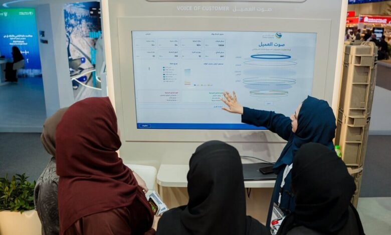 Woman in hijab pointing at a digital display showing customer feedback data.