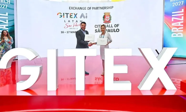 Man and woman shaking hands in front of GITEX AI LATAM Sao Paulo banner