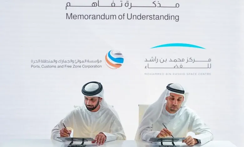 Two men in traditional Emirati attire signing a Memorandum of Understanding.