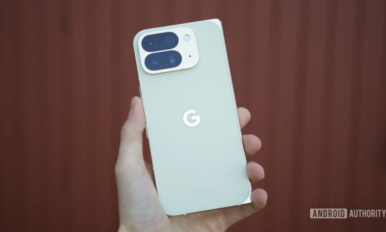 Close-up of a light green Google Pixel phone held in a hand, showing the camera array and Google logo.