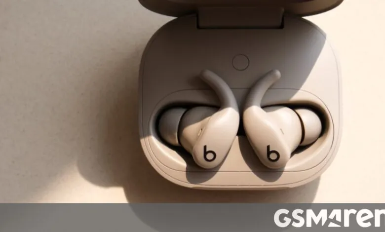 Beats Fit Pro wireless earbuds in a light beige charging case, angled view.