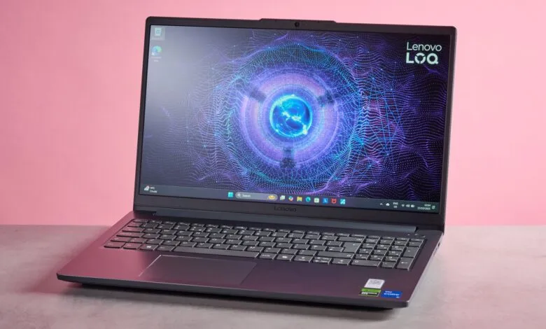A dark gray Lenovo LOQ laptop with a vibrant, abstract digital wallpaper displayed on its screen.