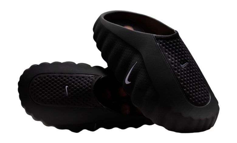 A pair of black Nike clogs with perforated detailing and white Nike logos.