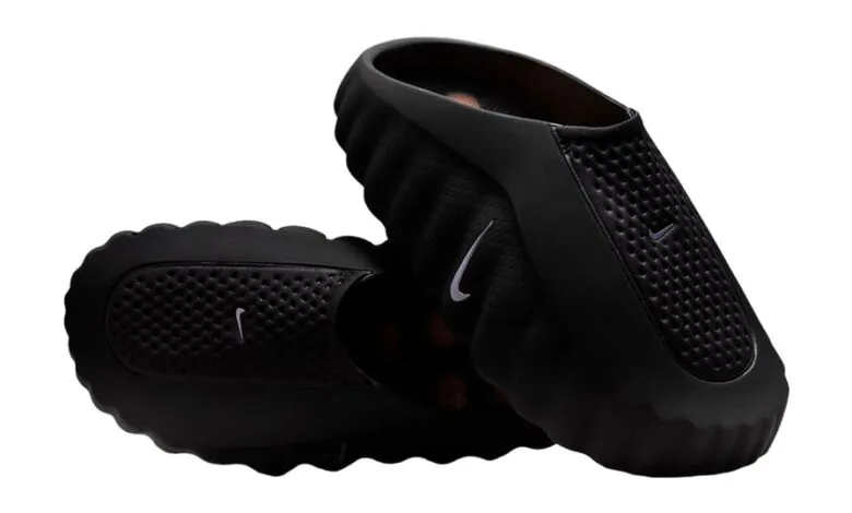 A pair of black Nike clogs with perforated detailing and white Nike logos.
