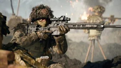Soldier in camouflage aiming a sniper rifle with a scope, with another soldier in the background.