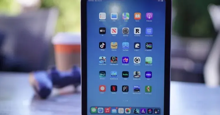Close-up of an iPad screen displaying various app icons on a blue background.