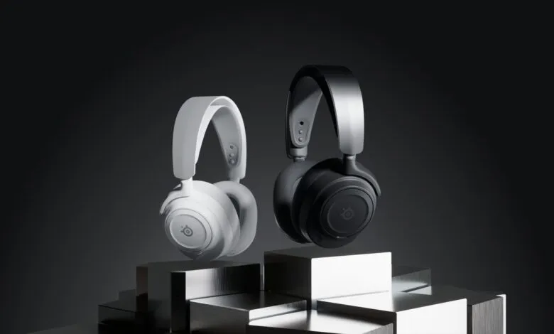 Two SteelSeries gaming headsets, one white and one black, displayed on metallic platforms.
