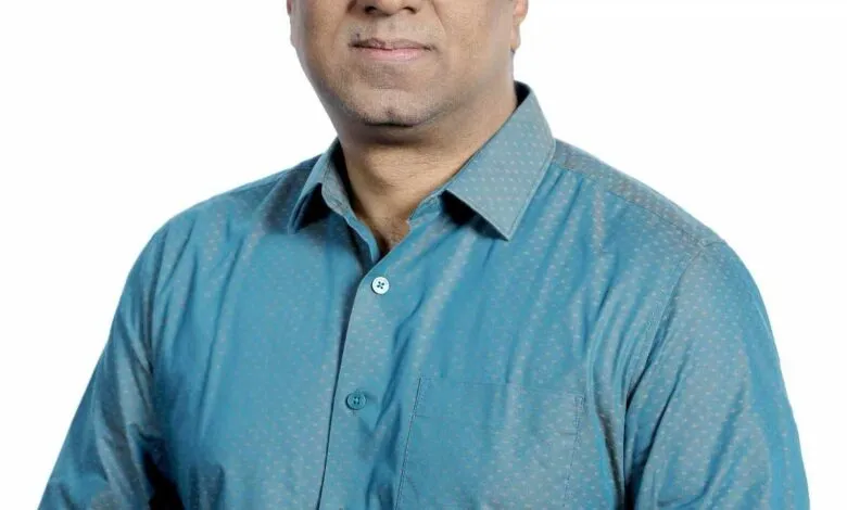 Portrait of a man wearing glasses and a blue patterned shirt