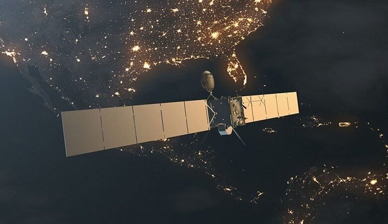 A satellite with large solar panels orbits above Earth at night, showing illuminated cities.