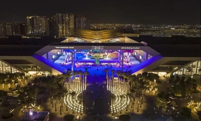 Aerial view of the Dubai Exhibition Centre at night, illuminated with blue and white lights.
