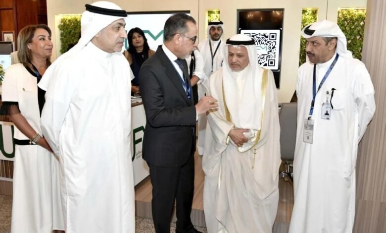 Men in traditional Arabic attire and a man in a suit converse at an event.